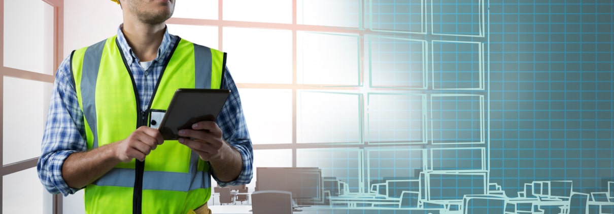 Concentrated Construction Worker With Tablet against interior of empty office